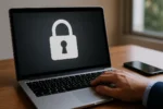 Close-up of a laptop displaying a padlock icon on screen, symbolising online privacy and data protection, with a person’s hand resting on keyboard in a bright Australian home office.